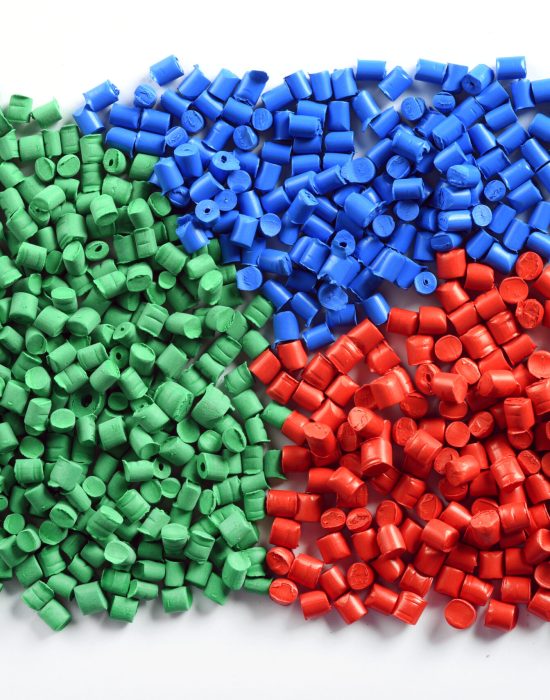 Colorful collection of molded plastic pellets or granules made from recycled waste to be reused in the industry as a raw material to manufacture products